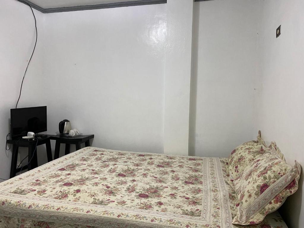 KaybagalにあるSn David Apartelleのベッドルーム1室(花柄のベッドカバー付)