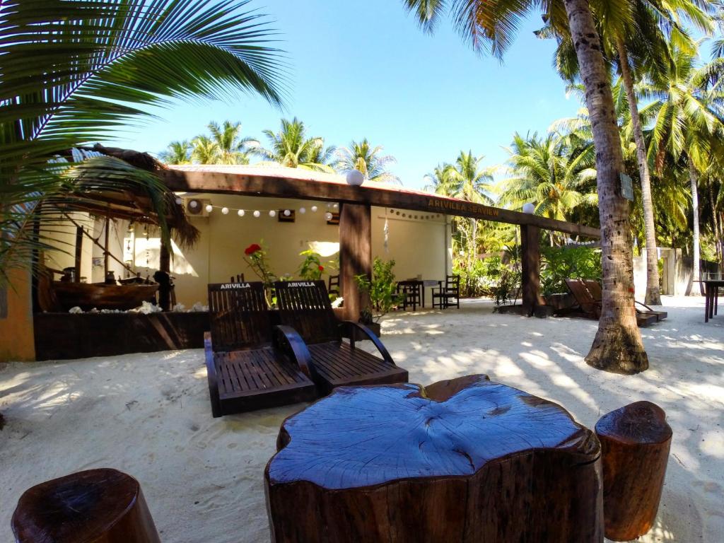 a resort with two chairs and a bed in the sand at Arivilla Beach in Mathiveri