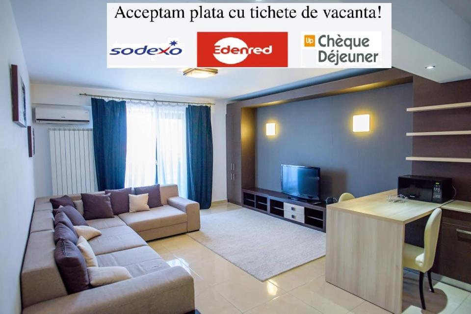 a living room with a couch and a tv at C&Y Zev Apartments in Mamaia