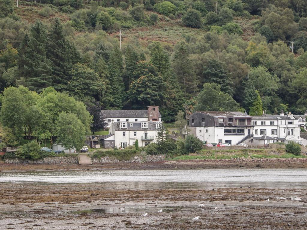 um grupo de casas na costa de uma massa de água em Cairn View em Arrochar