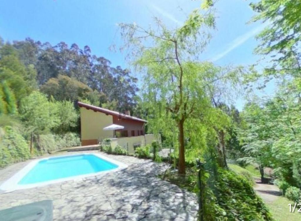 a villa with a swimming pool in a garden at Aliga Etxea. Beach & Mountain Village in Getxo