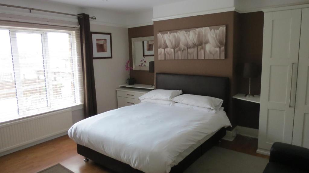 um quarto com uma grande cama branca e uma janela em The Lion Waddesdon em Waddesdon
