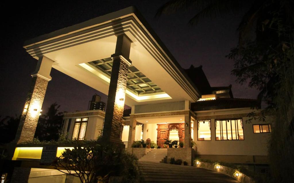 a large white house with lights at night at Ndalem Nuriyyat Villa, Spa & Skin Care in Yogyakarta