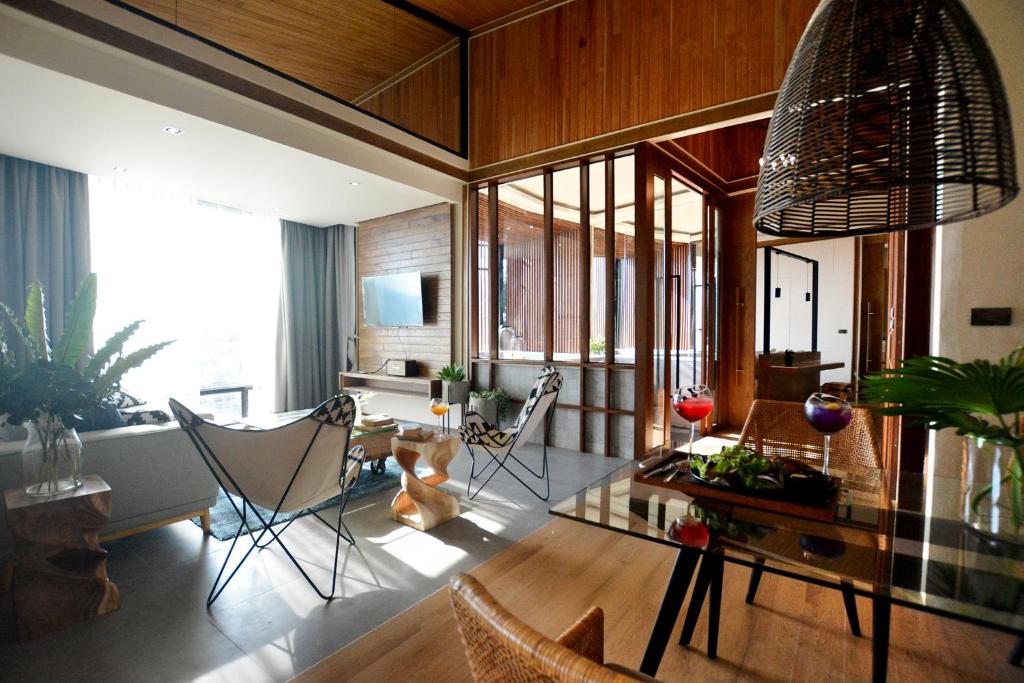 a living room with a glass table and chairs at The Cabin Beach Resort in Haad Rin