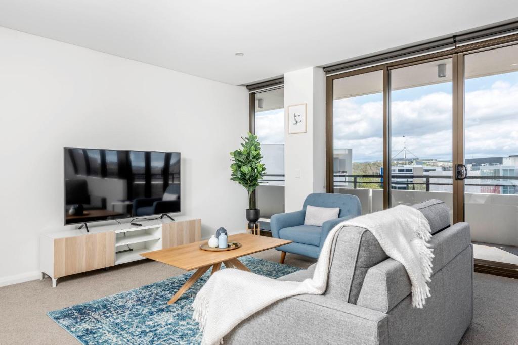 a living room with a couch and a tv at Luxe 2 Bedroom Apartment in Barton in Kingston 