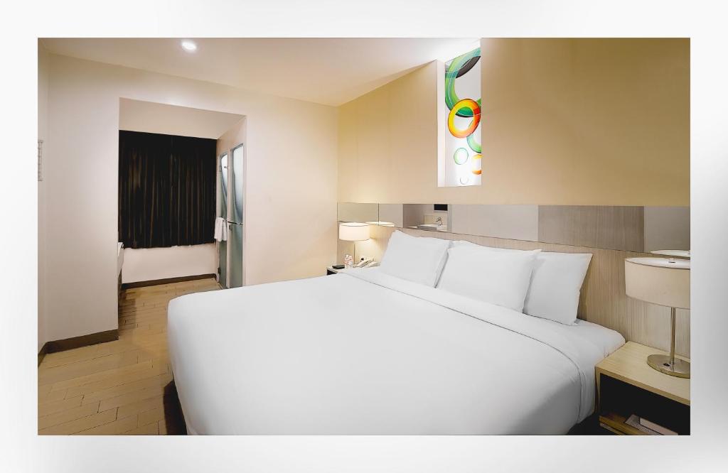 マニラにあるGo Hotels Ortigas Centerのホテルルーム内の大きな白いベッド