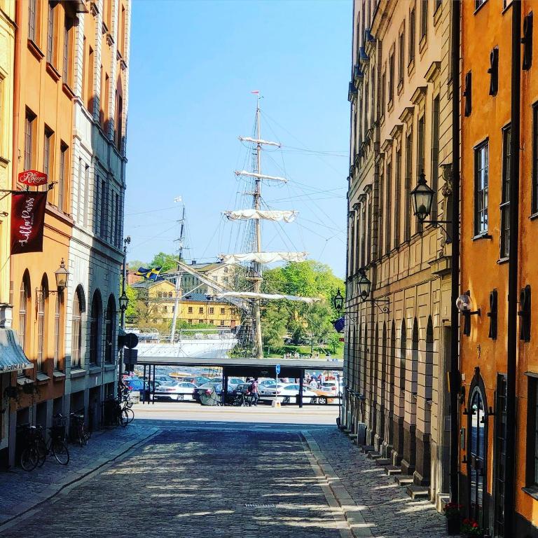Hotel Gamla Stan Apartments, an empty street with a tall ship in the distance at Gamla Stan Apartments in Stockholm