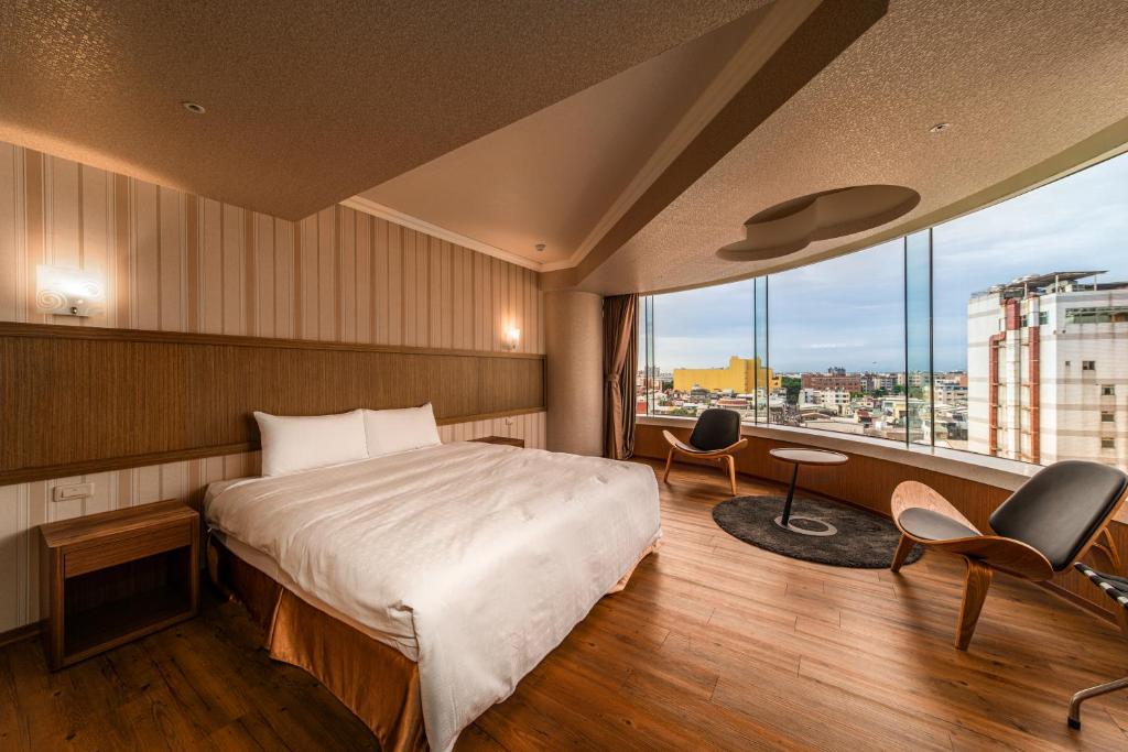 a hotel room with a bed and a large window at Fish Hotel-Pingtung in Pingtung City