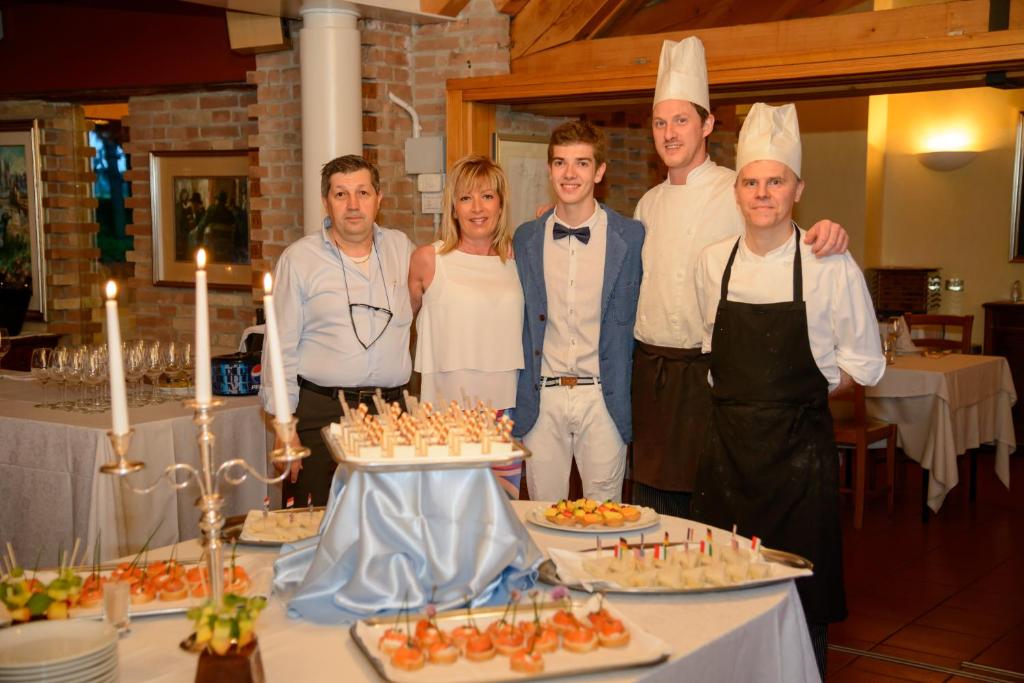 a group of people standing in front of a table with food at Hotel Del Parco Ristorante Loris in Pieve di Soligo