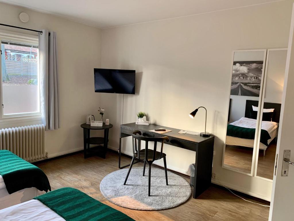 a bedroom with a desk and a bed and a bed at Rasta Arboga in Arboga