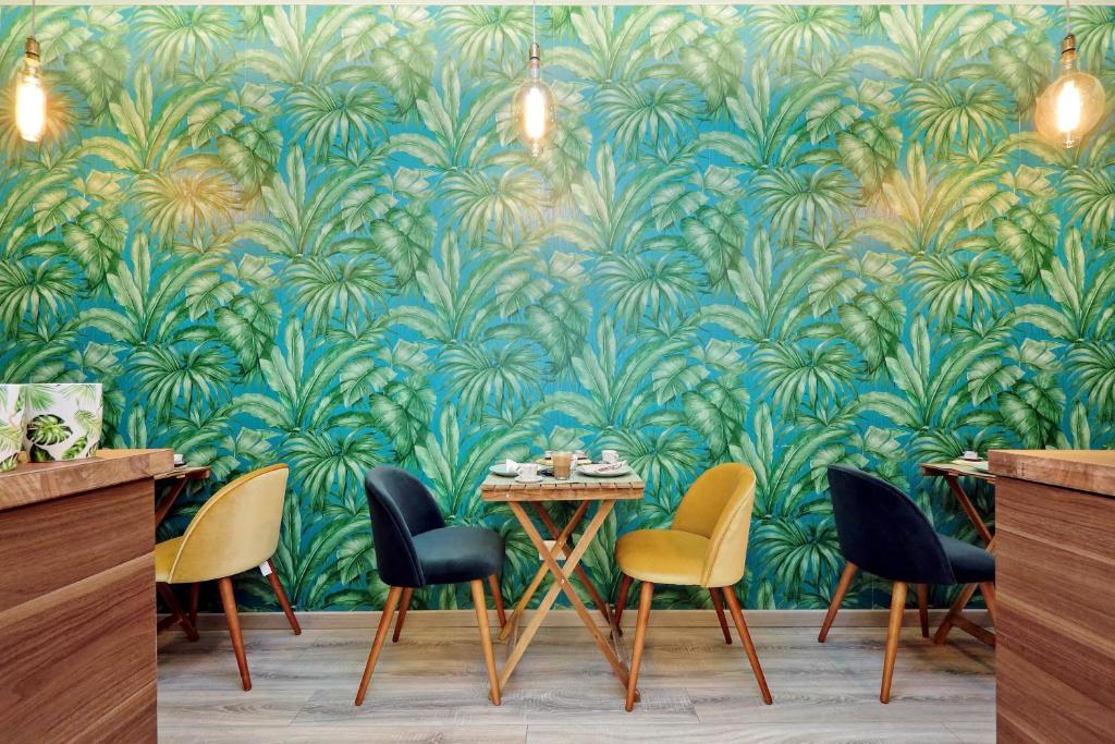 a dining room with a blue and green wallpaper at Roma Suite Monti in Rome