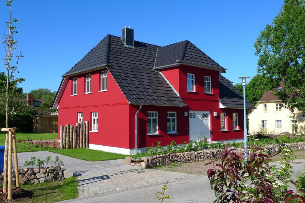 a red house with a black roof at Haus STRANDHAFER WF-07 (rechts) in Wustrow