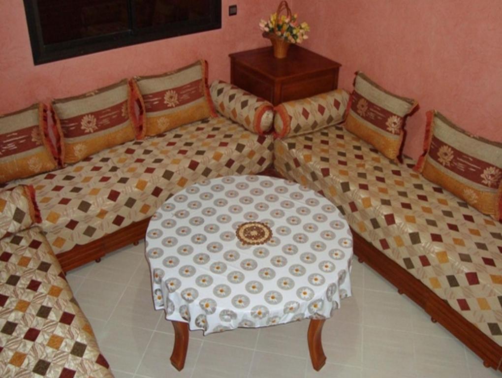 1 cama con mesa y sillas en una habitación en Silia Appartements en Temara