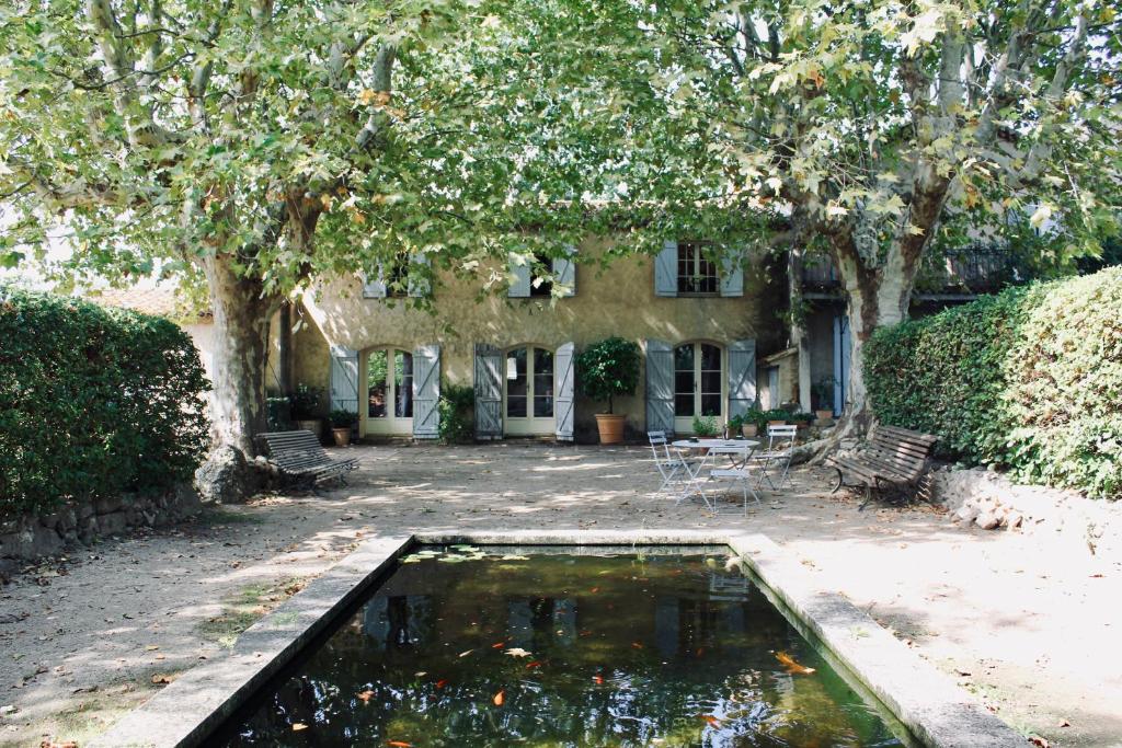 a pool of water in front of a house at LA GRACETTE Les Studios in Aix-en-Provence
