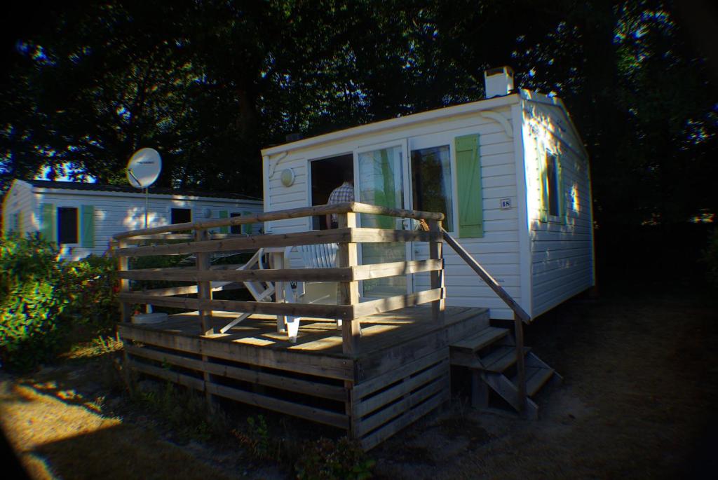 a white tiny house with a porch and a deck at Camping La Venise Du Bocage in Nesmy
