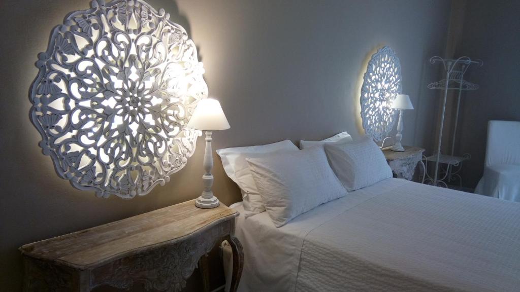 a bedroom with a bed and a chandelier at Hotel Silva in Alberobello