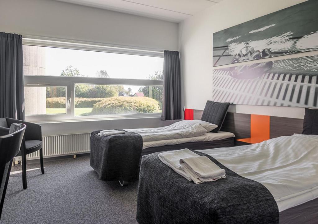 a hotel room with two beds and a window at Sportshotel Vejen in Vejen