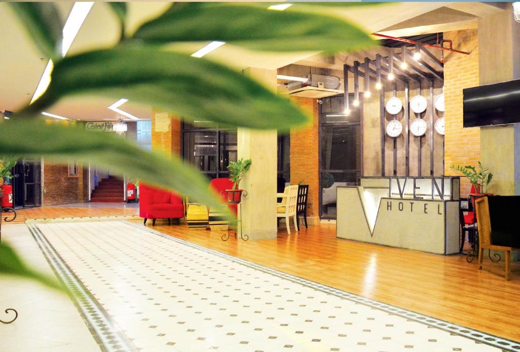 a view of a lobby with red chairs and a table at Viven Hotel in Laoag