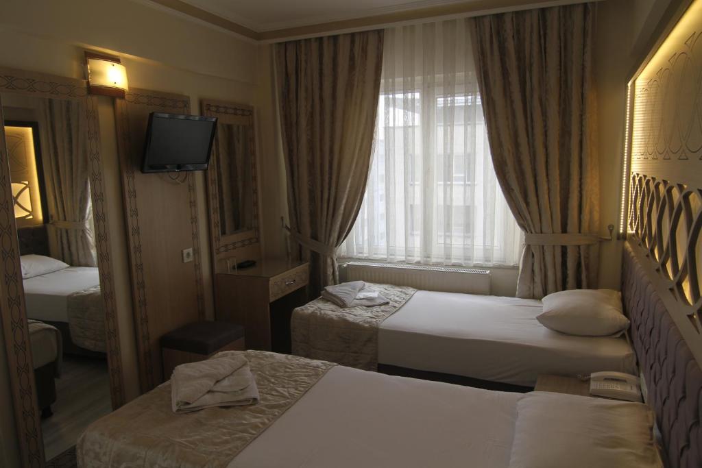Postel nebo postele na pokoji v ubytování Grand Liza Hotel