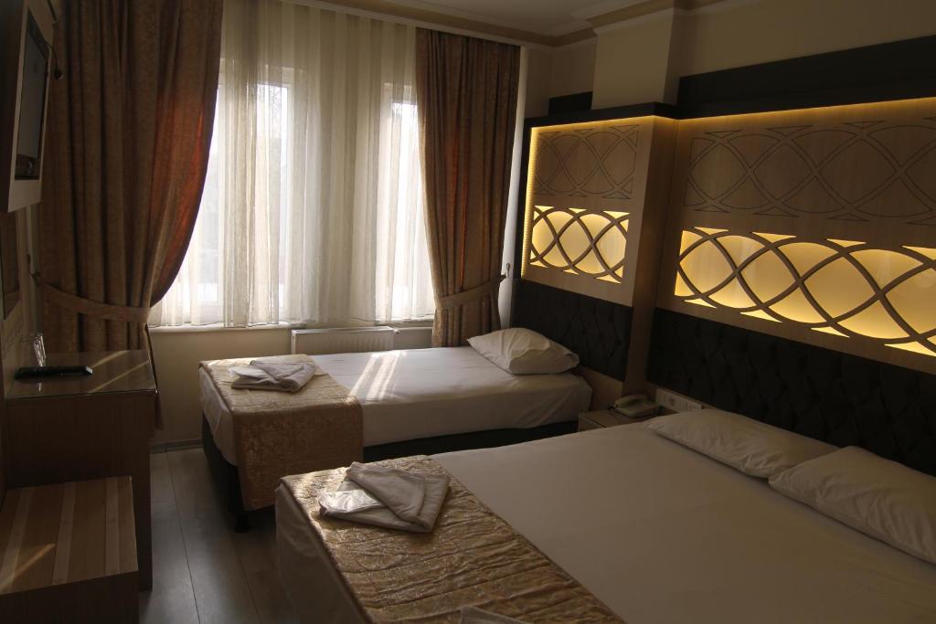Postel nebo postele na pokoji v ubytování Grand Liza Hotel