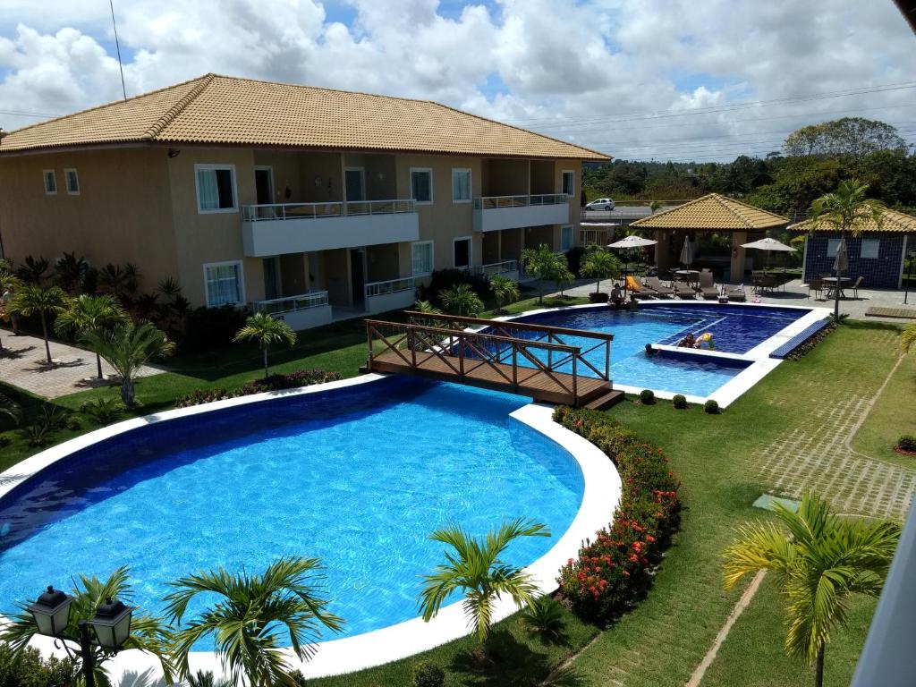 una vista aérea de una piscina del complejo con palmeras en Residencial Verano 105C, en Guarajuba