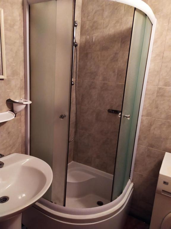 eine Dusche mit Glastür neben einem Waschbecken in der Unterkunft Прокофьева 24б Уютная посуточная квартира in Sumy