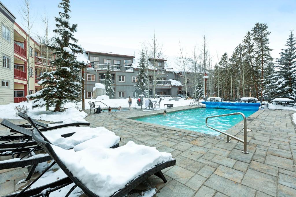 a swimming pool covered in snow next to a building at Expedition Station in Keystone