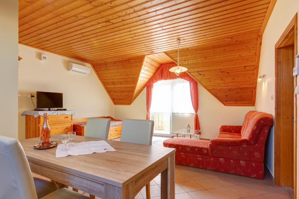 uma sala de estar com uma mesa e um sofá vermelho em Andrea Villa Hévíz I Balaton em Hévíz
