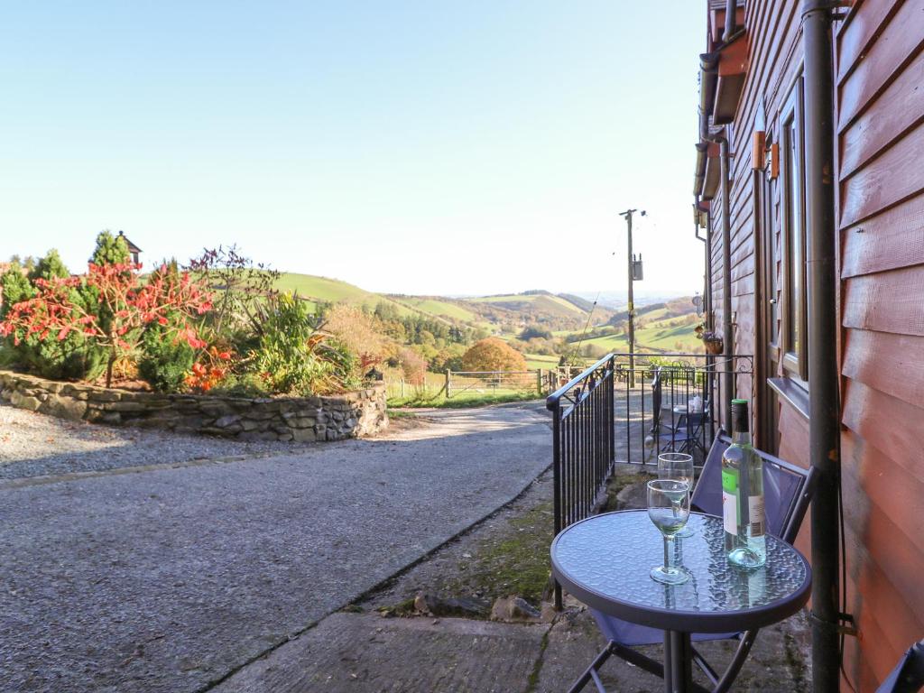 a table with wine glasses sitting on a street at Beech Cottage in Llanidloes