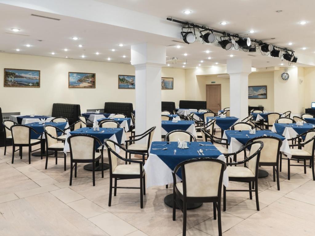 um salão de banquetes com mesas e cadeiras azuis em Avialuxe Hotel em Moscou