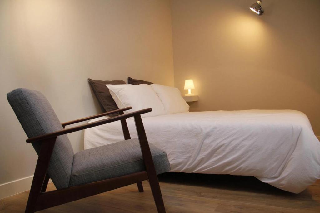 une chambre avec un lit et une chaise dans l'établissement DIFY Jaboulay - Jean Macé, à Lyon