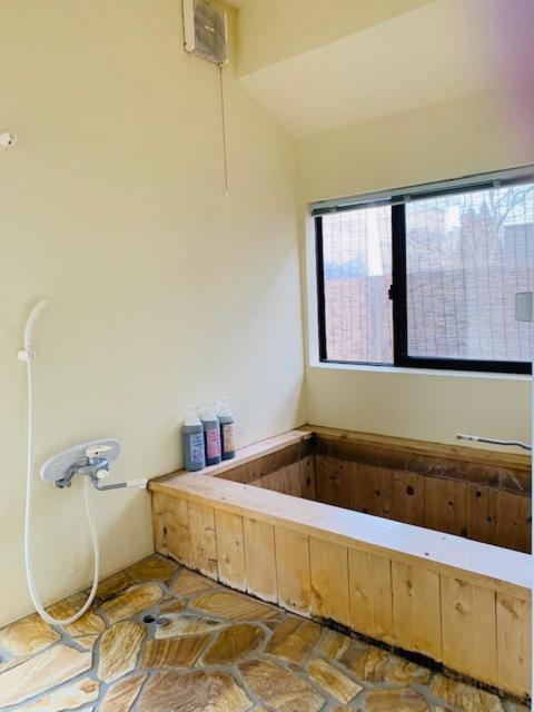 La salle de bains est pourvue d'une baignoire et d'une fenêtre. dans l'établissement Yufuin-Sanso Waremokou, à Yufu