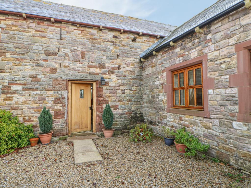 a brick building with a wooden door and potted plants at The Barn in Brampton