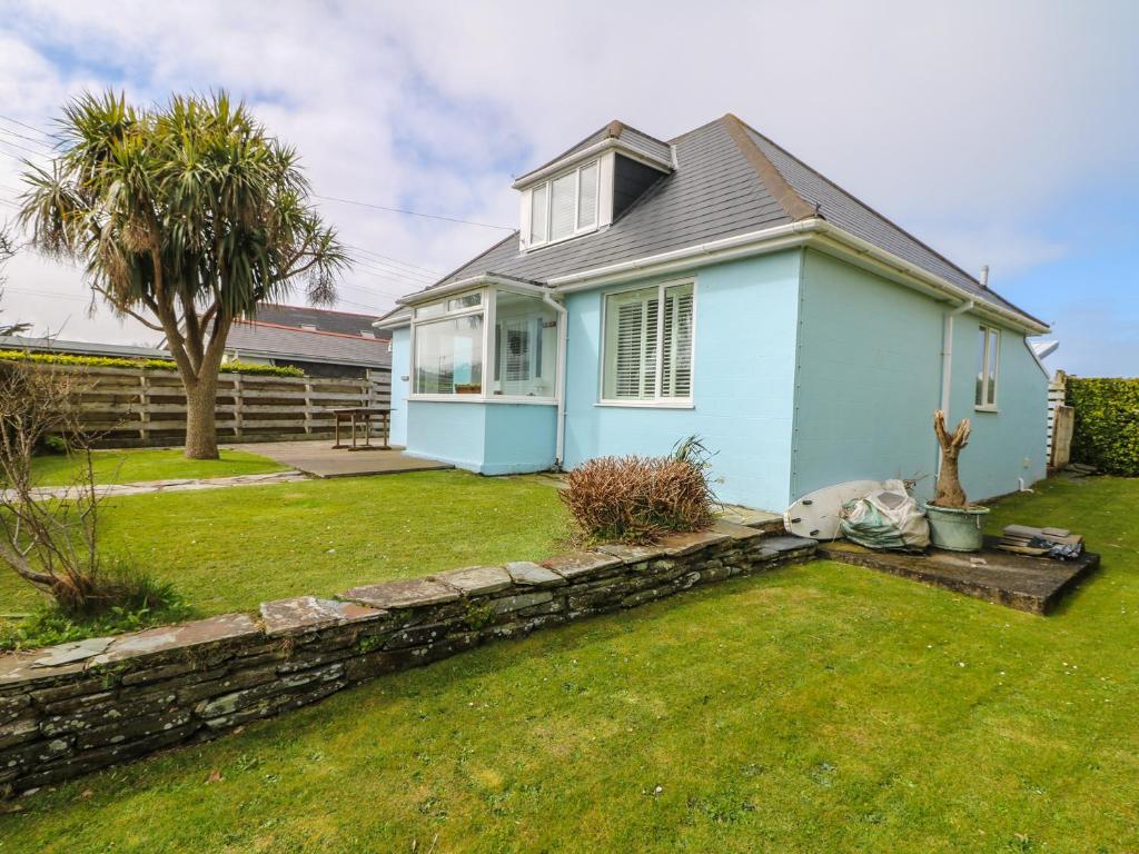 ein blaues Haus mit einer Steinmauer im Hof in der Unterkunft Bolenowe in Polzeath