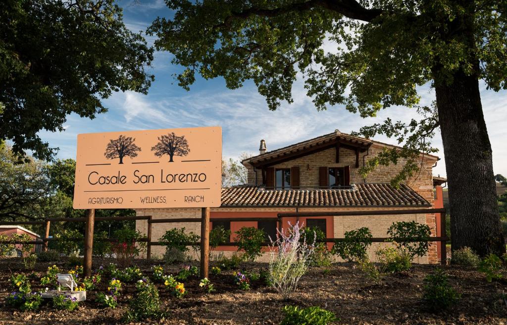 un edificio con un cartel frente a una casa en Agriturismo Casale San Lorenzo, en San Lorenzo in Campo