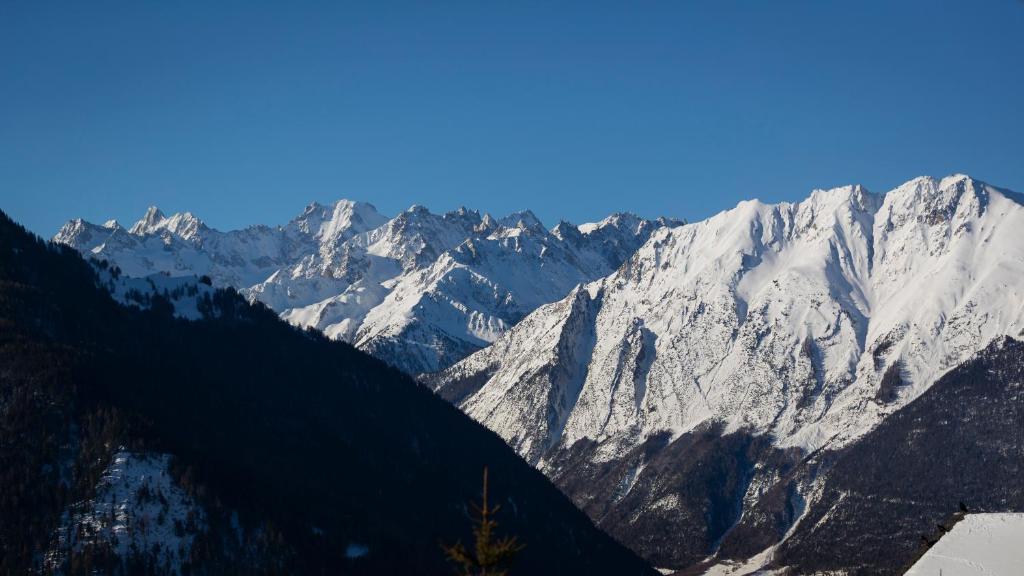 a view of a mountain range with snow covered mountains at Hotel Montpelier in Verbier