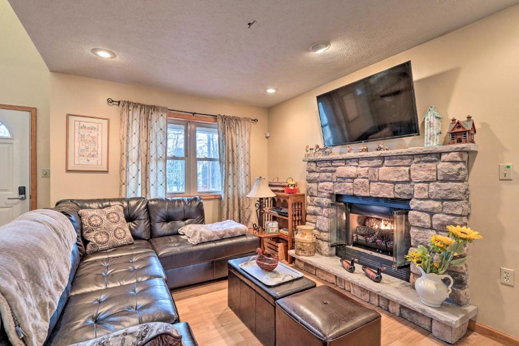 a living room with a couch and a stone fireplace at Walk to Pool and Lake Albrightsville Vacation Home! in Albrightsville