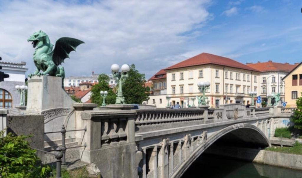 a statue of a man on a bridge near a river at Apartments Maria in Ljubljana