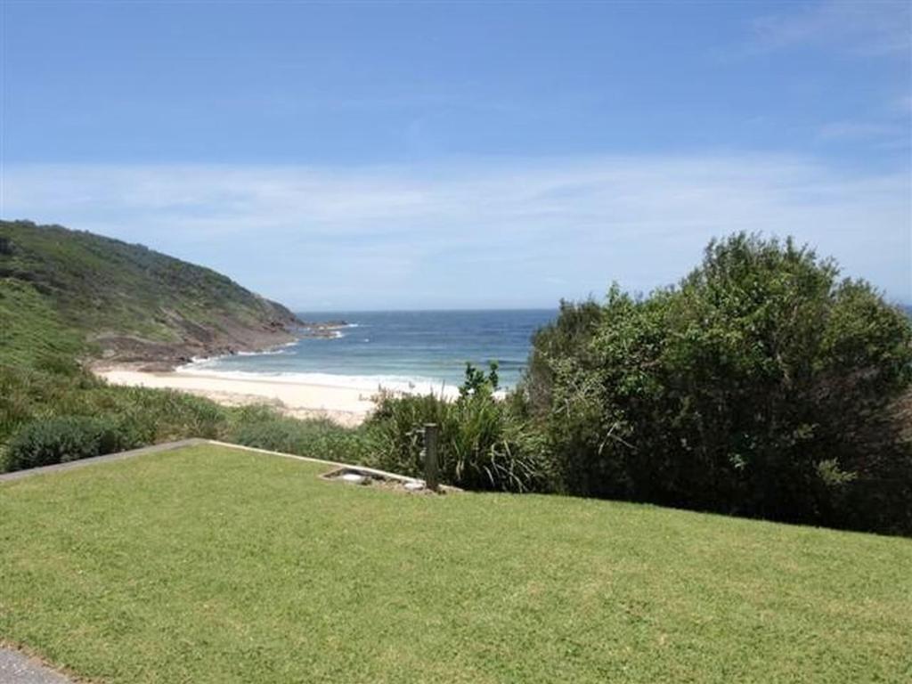 a view of a beach with the ocean in the background at @BLUEYS in Blueys Beach