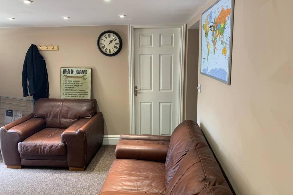 sala de estar con sofá y reloj en la pared en a COSY CLEAN GROUND FLOOR FLAT CLOSE TO TOWN CENTRE en Boston