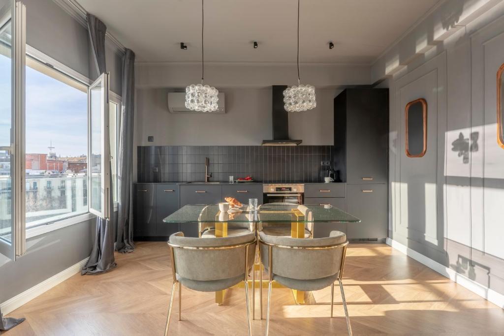 a kitchen with a glass table and chairs at TSA Gran Via in Barcelona