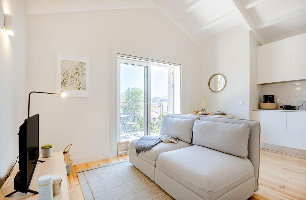 un soggiorno bianco con divano e finestra di Porto Downtown Studio with Balcony a Porto