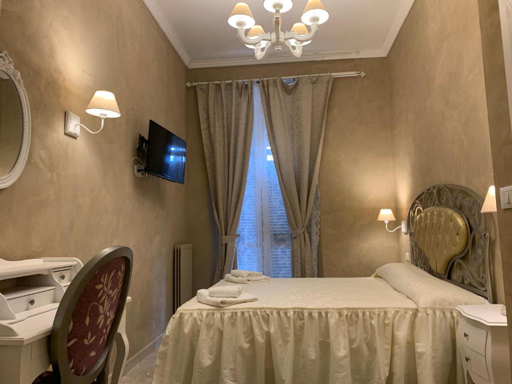 a bedroom with a bed with a mirror and a window at Boutique Hotel Calais Milano in Milan