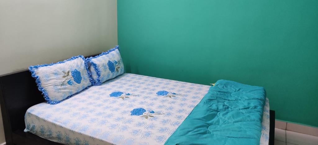 łóżko z niebiesko-białą pościelą i poduszkami w obiekcie Garden House w mieście Mysuru