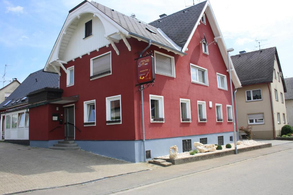 a red building on the side of a street at Gasthaus Sonne in Merklingen