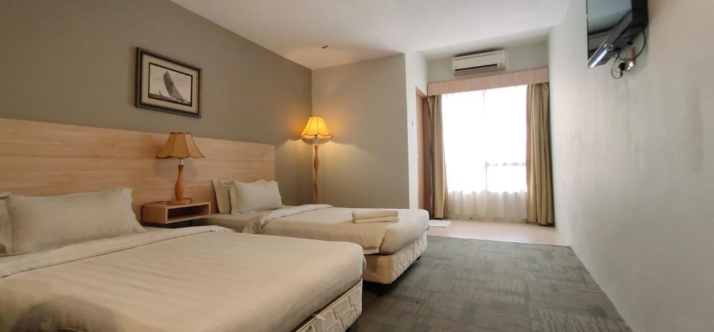 Postel nebo postele na pokoji v ubytování Prima Hotel Melaka