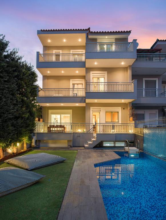 a large building with a swimming pool in front of it at Athenian Grand Riviera Villa in Athens