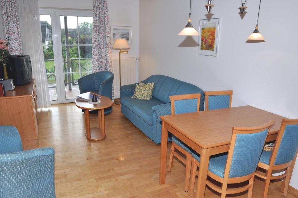 uma sala de estar com um sofá azul e uma mesa em Nautic 12 em Laboe