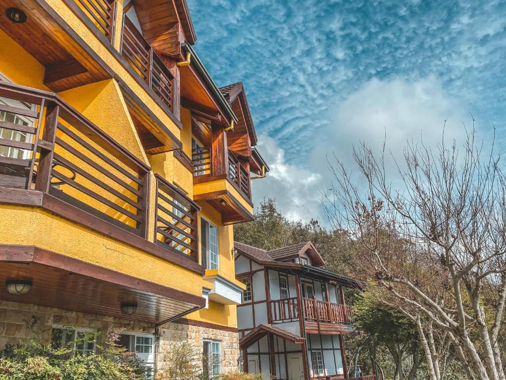 a yellow building with wooden balconies on it at Euro Country Villa in Ren&#39;ai