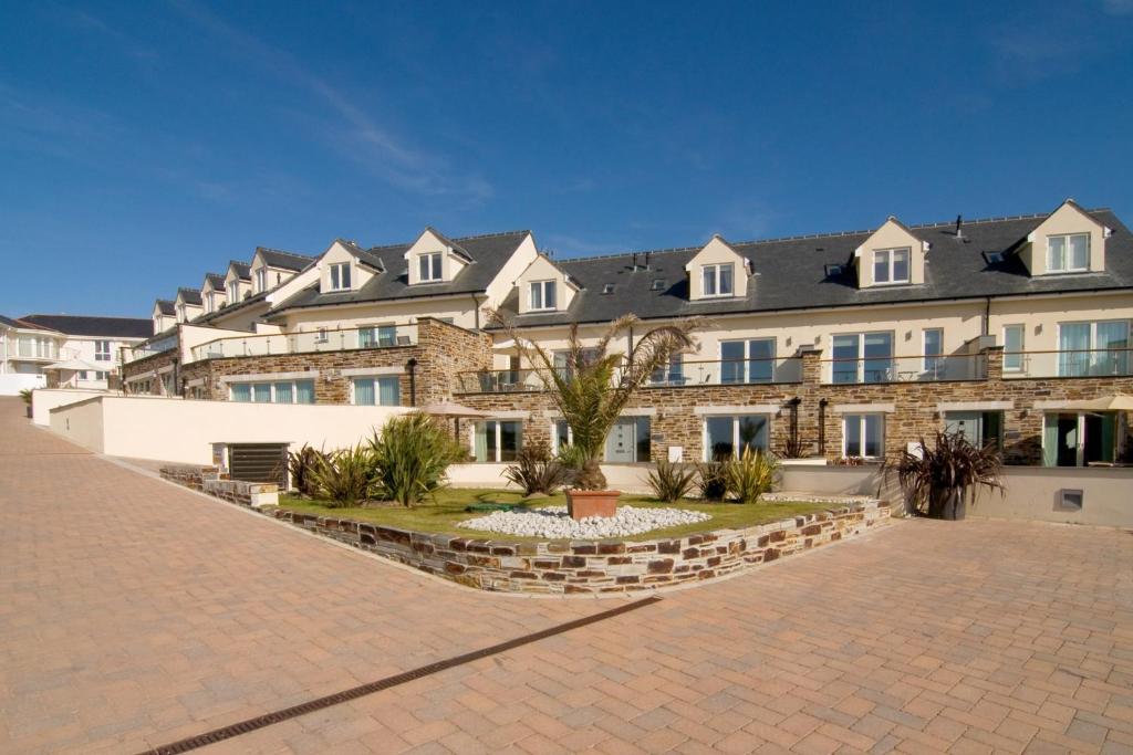 a large brick building with a lot of windows at BEACHSIDE SPACIOUS apartment, private garden in St Merryn